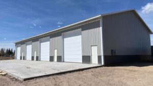 a metal barn with a slab of concrete in front